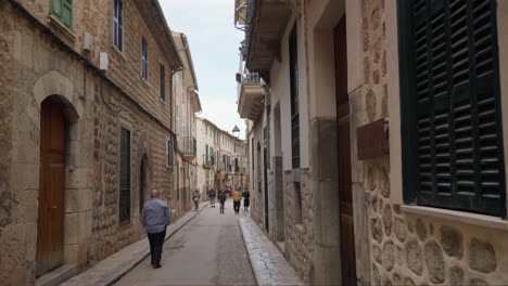 Quiet-alley-in-Soller,-Mallorca-with-strolling-people