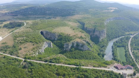 Retreating-drone-shot-of-the-panoramic-view-of-Prohodna-cave,-a-geological-park-located-in-Lukovit-Municipality,-in-Karlukovo,-Bulgaria