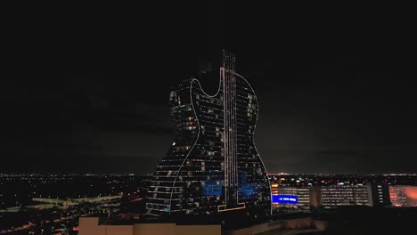 An-aerial-view-of-the-guitar-shaped-Seminole-Hard-Rock-Hotel-and-Casino-illuminated-with-lights-at-night