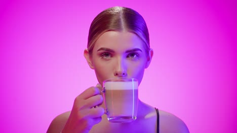 Süße-Brünette-Frau-Nimmt-Einen-Schluck-Süßen-Macchiato-Kaffeetasse,-Studioaufnahme