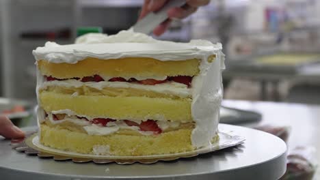 Mire-Cómo-El-Pastel-Cobra-Vida:-Un-Primer-Plano-Captura-Una-Mano-Aplicando-Hábilmente-Fondant-En-Un-Delicioso-Pastel.