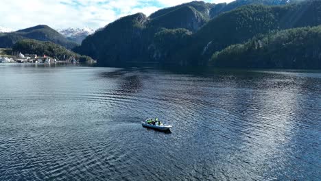 RIB-boat-with-tourist-stopping-at-Veafjord-for-guiding,-60-Fps-aerial-circle-around