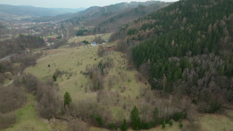 Vista-Aérea-De-Jedlina-zdrój,-Que-Muestra-El-Encanto-Rústico-De-Este-Pueblo-De-Montaña-En-Polonia,-Con-Sus-Colinas,-Densas-áreas-De-árboles-De-Hoja-Perenne-Y-Casas-Dispersas.