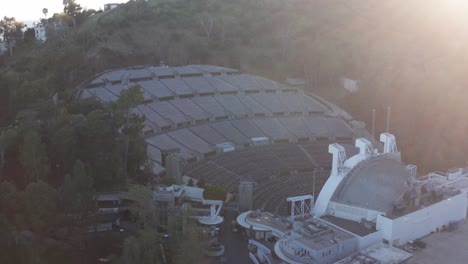 Toma-Aérea-Panorámica-Baja-Del-Hollywood-Bowl-Al-Atardecer-Con-Destellos-De-Lente-En-Los-Ángeles,-California