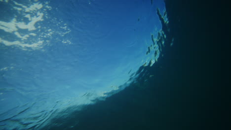 Mysterious-deep-blue-ocean-view-from-underwater-of-back-of-breaking-crashing-wave-down-the-line