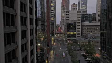 Calgary-AB-Canada-Aerial-v61-low-drone-flyover-downtown-commercial-in-between-high-rise-buildings-along-5-Ave-Sw-capturing-cityscape-and-street-traffic-at-dusk---Shot-with-Mavic-3-Pro-Cine---July-2023