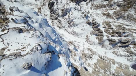 Akrobatische-FPV-Drohne,-Die-Mit-Hoher-Geschwindigkeit-über-Den-Schneebedeckten-Berggipfel-Von-Resegone-In-Den-Italienischen-Alpen-Fliegt