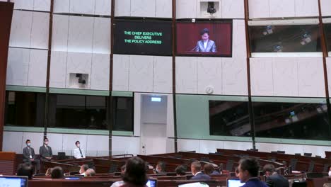 Carrie-Lam,-Ex-Directora-Ejecutiva-De-Hong-Kong,-Aparece-En-La-Pantalla-De-La-Cámara-Principal-Mientras-Pronuncia-El-Discurso-Político-Anual-En-El-Edificio-Del-Consejo-Legislativo.