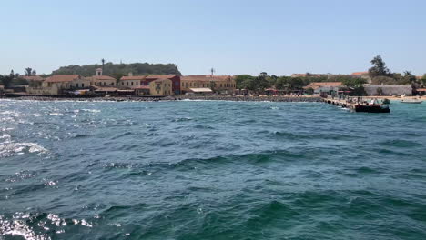 Tourist-ferry-arrives-at-Gorée-Island,-just-off-the-coast-from-Dakar