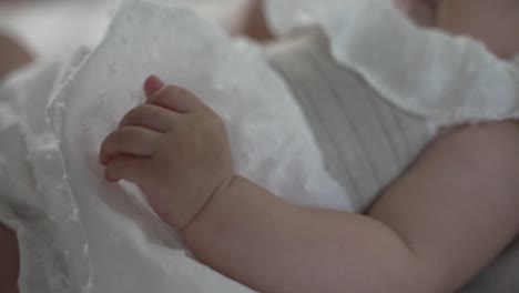Infant's-hand-gently-resting-on-soft-blanket