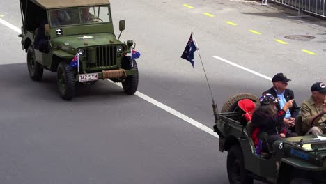Veteranen,-Die-Auf-Einem-Historischen-Militärfahrzeug-Fahren,-Stolz-An-Der-Anzac-Day-Parade-Teilnehmen-Und-Die-Unterstützung-Der-Australischen-Bürger-Anerkennen