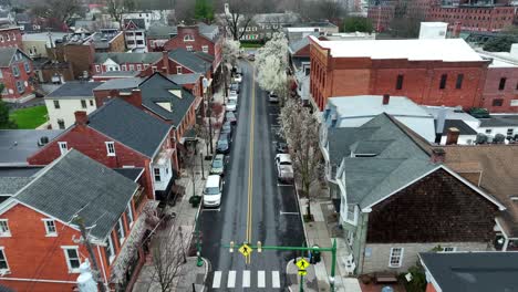 Aerial-establishing-shot-of-main-street-in-american-town-with-red-brick-houses
