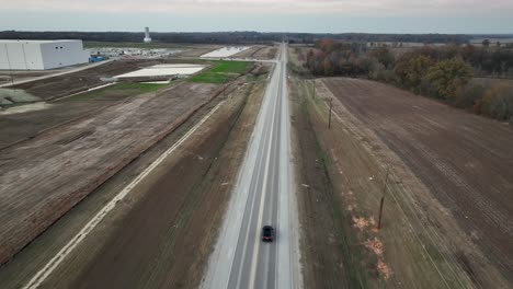 Aerial-following-vehicle-driving-along-Ford's-Megacampus,-BlueOval-City-at-Sunset-in-Stanton,-TN