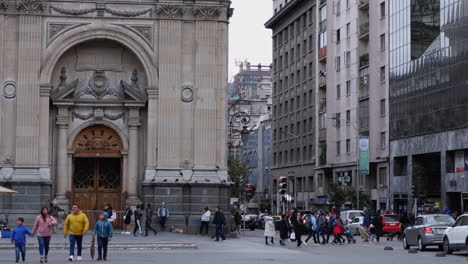 People-walk-past-facade-of-Metropolitan-Cathedral-in-Santiago,-Chile