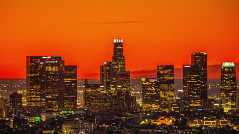 Zeitraffer,-Nacht-über-Den-Türmen-Des-Finanzviertels-Von-Los-Angeles,-Orangefarbener-Himmel-Und-Gebäude-In-Lichtern