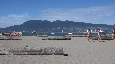 Mujeres-Jóvenes-En-La-Playa-En-Verano,-Barcos-En-Segundo-Plano.