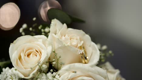 Ramo-De-Rosas-Blancas-Con-Brillantes-Anillos-De-Boda-Entre-Sus-Pétalos