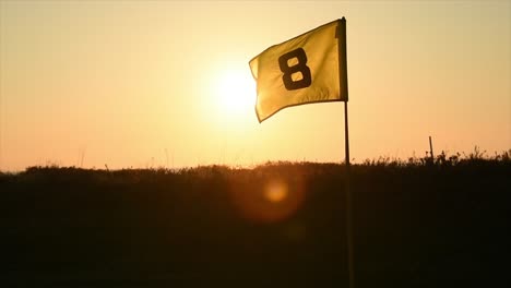 Golfflagge-Bei-Sonnenuntergang-Mit-Sonnenstrahlen