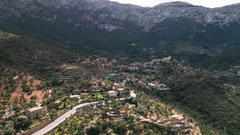 Aerial-view-of-Deia-village-in-Mallorca-with-scenic-mountain-backdrop