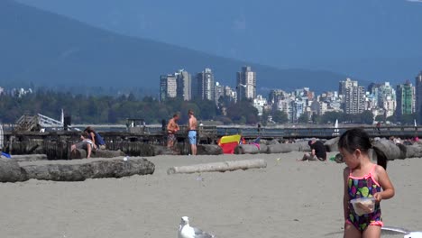 Funny-little-girl-feeds-seagulls-at-the-beach