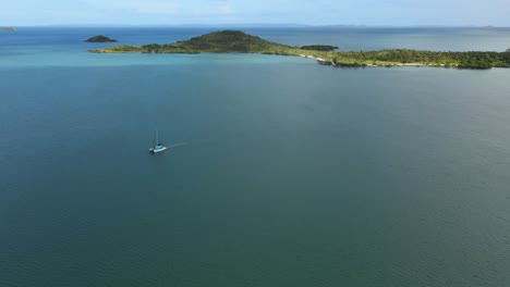 Luftaufnahme-Eines-Katamarans-Auf-Dem-Ruhigen-Meer,-Tropischen-Inseln-Und-Sonnenschein-Im-Hintergrund