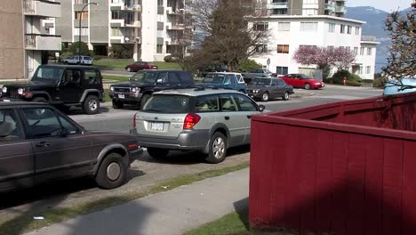 Pan-shot-of-car-turning-off-street-into-a-back-alley