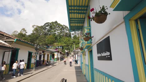 Vibrante-Edificio-Recortado-En-Amarillo-Azul-En-Las-Calles-De-Salento-Colombia-Frente-Al-Bosque-Selvático