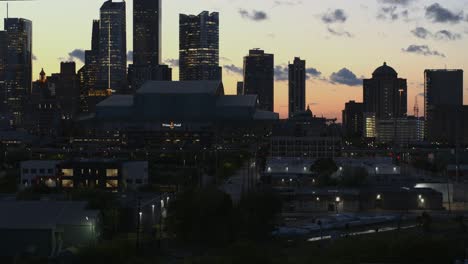 Aufsteigende-Drohne-Drohne-Von-Bäumen,-Die-Innenstadt-Von-Houston-Bei-Nacht-Offenbaren