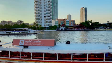 Dolly-Aufnahme-Von-Booten,-Die-Sich-Bei-Sonnenuntergang-Auf-Dem-Chaopraya-Fluss-In-Bangkok,-Thailand,-Bewegen