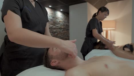 Ein-Paar-Bekommt-Eine-Massage-In-Einem-Spa,-Es-Ist-Eine-Duo-Massage,-Zwei-Profis-Massieren-Ihre-Köpfe