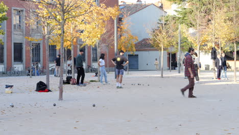 Junge-Leute-Im-öffentlichen-Park-Spielen-Petanque-Auf-Dem-Boden-In-Toulouse,-Frankreich