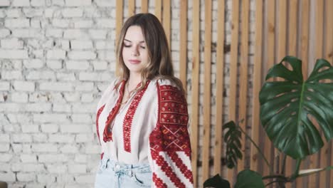 lovely-girl-dancing-in-an-embroidered-authentic-Ukrainian-shirt-cheerfully-adjusts-her-hair-with-a-smile