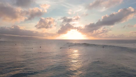 Volando-Sobre-El-Océano-Pacífico-En-Hawai,-Los-Surfistas-Flotan-En-El-Agua-Y-Atrapan-Olas