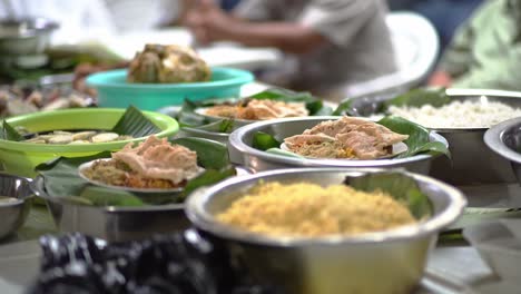 Traditional-Indonesian-wedding-food-in-banana-leaves,with-people-in-background