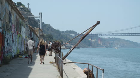 Menschen,-Die-Entlang-Der-Promenade-Am-Fluss-In-Lissabon,-Portugal-Spazieren
