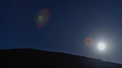 Glühend-Heller-Mond-Geht-über-Bewaldeten-Bergen-Mit-Tiefblauem-Himmel-Und-Sternen-Auf