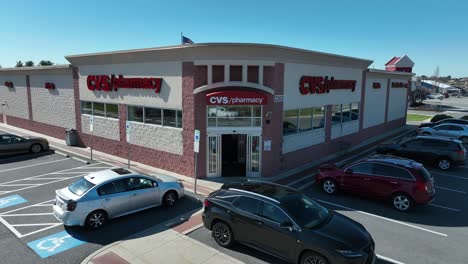 Aerial-approaching-shot-of-male-person-entering-CVS-Pharmacy-in-American-Town
