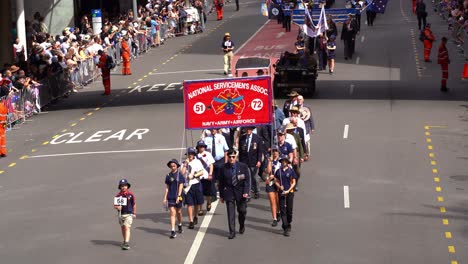 Representatives-from-the-National-Servicemen's-Association-in-Army,-Navy-and-Air-Force,-walking-down-the-street,-participating-the-parade-tradition,-amidst-the-solemnity-of-the-Anzac-Day-commemoration