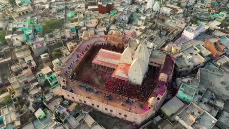 Aerial-drone-view-of-the-temple-is-being-cleaned-by-the-police-functionary-near-the-temple-and-the-temple-is-being-properly-washed-by-water-Down-below-there-are-many-tourist-coming-out-to-play-Holi