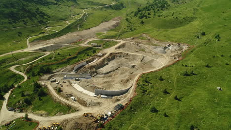 Toma-Aérea-De-Arriba-Hacia-Abajo-De-Un-Sitio-De-Construcción-De-Una-Presa-En-Las-Montañas-Alpinas