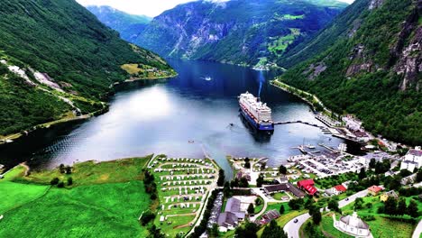 Aerial-View-of-Cruise-Ship-in-Fjord,-Geiranger-Village-Port,-Scenic-Landscape-and-Tourist-Attraction-of-Norway-60fps