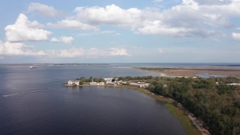 Aerial-wide-rising-shot-of-Fort-Johnson-with-Fort-Sumter-in-the-distance-in-Charleston-Harbor,-South-Carolina