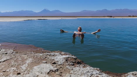 Man-enjoys-sunny-swim-in-extra-buoyant-saline-Laguna-Piedra-in-Chile