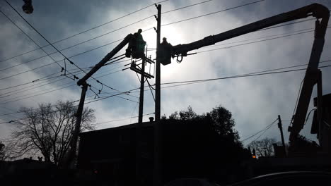 Toma-Amplia-En-ángulo-Bajo-De-Trabajadores-Hidroeléctricos-De-Toronto-Trabajando-En-Lo-Alto-De-Una-Grúa