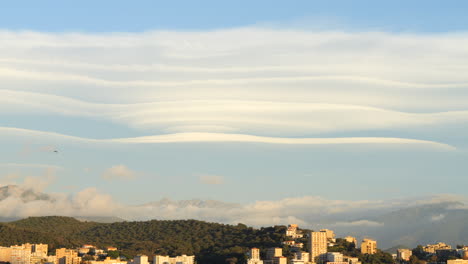 Lenticular-Clouds-Over-City-And-Forest-On-Sunny-Day