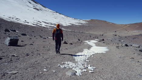 Wanderer-Geht-Auf-Kargen,-Schneebedeckten-Alpinen-Bergplateaus-In-Den-Chilenischen-Anden