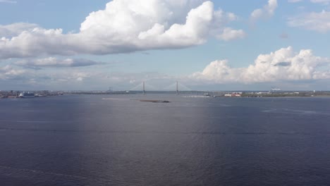 Aerial-super-wide-descending-shot-of-Charleston-Harbor-with-Ravenel-Bridge,-Patriot's-Point,-and-Castle-Pinckney-all-visible,-from-the-perspective-of-Fort-Johnson-off-James-Island,-South-Carolina