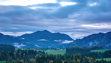 Time-lapse-of-Austrian-alps-Landscape-European-mountain-range-green-blue-skyline-Valley,-clouds-in-motion-becoming-dusk,-green-agricultural-fields