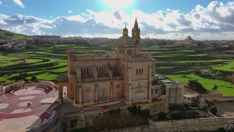 Drone-view-Of-Ta-Pinu-Church-With-Green-Landscape-on-a-Sunny-Day-in-Gozo-island,-Malta