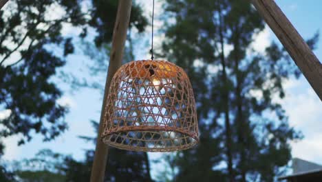A-lit-wicker-lamp-hanging-from-the-decoration-of-a-night-wedding-outside